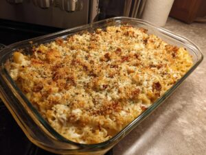 A golden-brown chicken bacon ranch casserole with a crispy breadcrumb topping, baked in a glass dish.