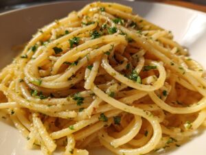 Close-up of a plate of creamy lemon pasta, tossed with herbs and a light sauce.