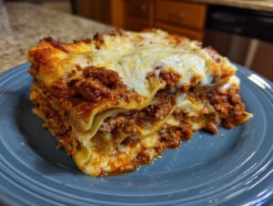 A delicious slice of easy lasagna with ricotta, featuring layers of pasta, meat sauce, and melted cheese.