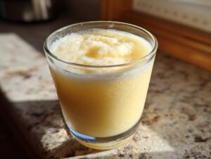 A close-up of a frosty yellow drink in a glass, perfect for a fall harvest salad.