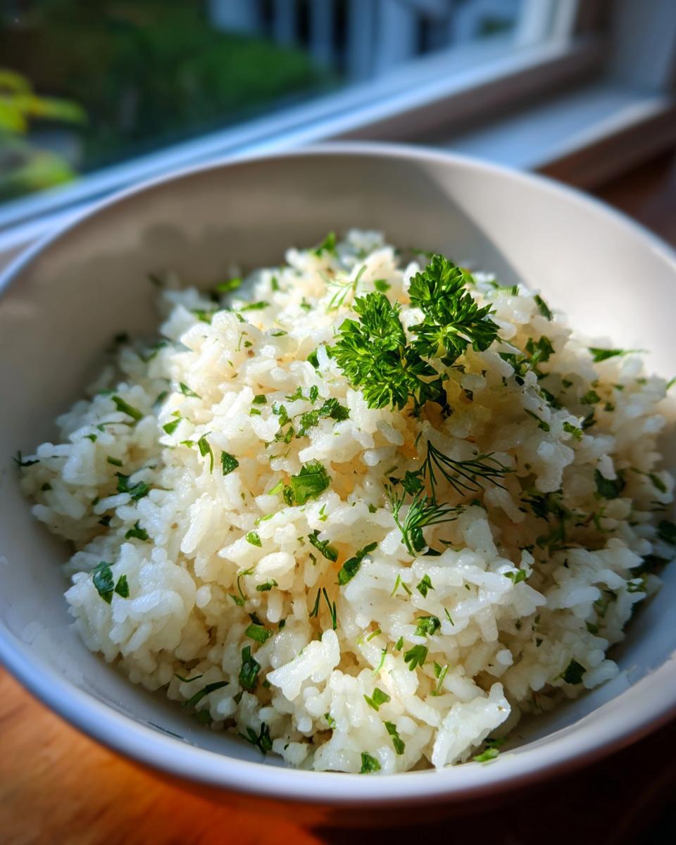 A close-up of fluffy Mediterranean lemon rice generously garnished with fresh parsley and dill.