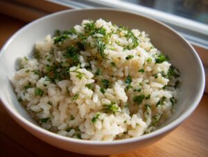A close-up of fluffy Mediterranean lemon rice generously sprinkled with fresh parsley and dill.