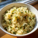 Close-up of fluffy Mediterranean lemon rice topped with fresh parsley and lemon zest.