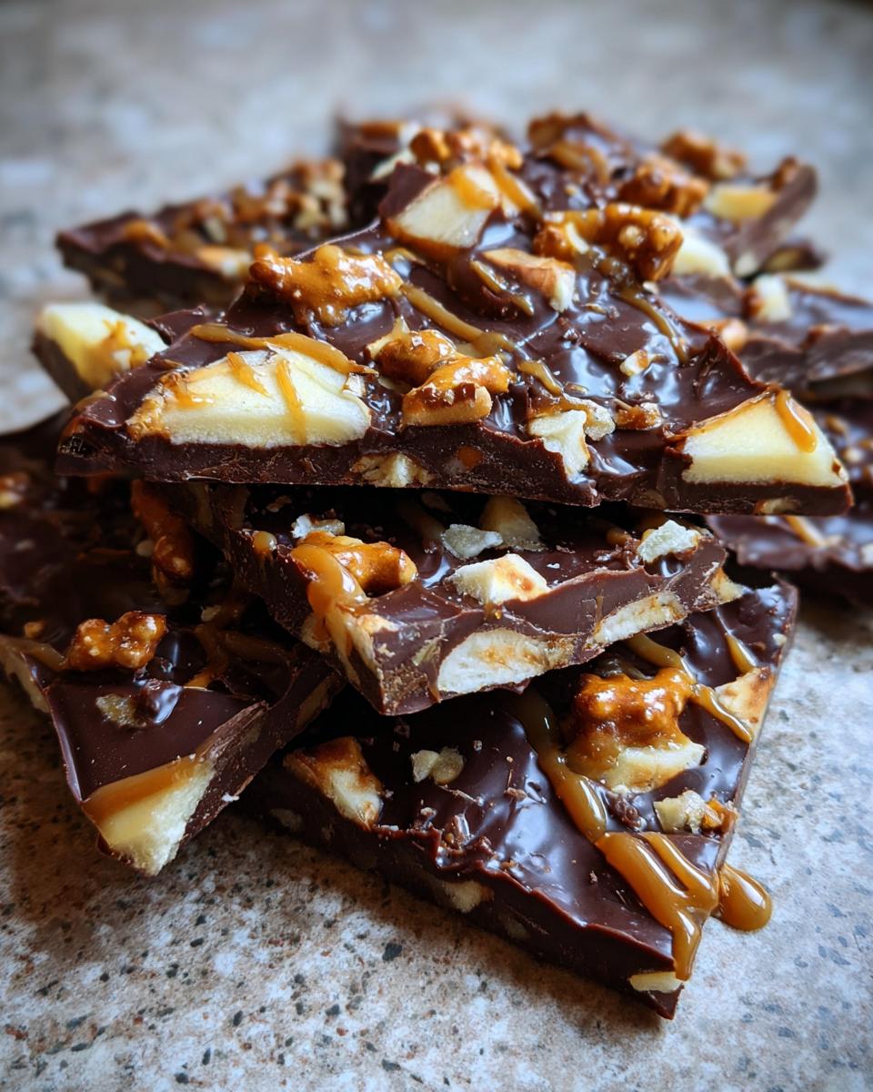 Close-up of a stack of chocolate bark pieces, a tamale pie casserole alternative, with nuts and caramel drizzle.