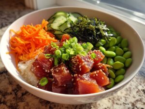A vibrant Tuna Poke Bowl filled with marinated tuna, rice, shredded carrots, edamame, cucumber, and nori.