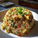 A perfectly molded mound of delicious chicken fried rice, topped with fresh green onions.