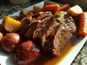 Close-up of tender, sliced pot roast covered in rich gravy, served with roasted potatoes and carrots.