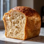 Close-up of a freshly baked sourdough sandwich bread loaf, showcasing its soft, open crumb texture.