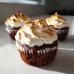 Three moist chocolate cupcakes topped with fluffy, toasted meringue frosting, featuring the primary keyword hot chocolate cupcakes.