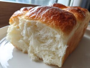 A close-up view showing the incredibly soft, fluffy, and stringy interior crumb of freshly baked japanese milk bread.
