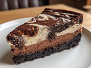 A decadent slice of 3 layer chocolate cheesecake with a dark crust and marbled topping.