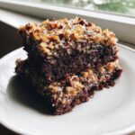 A rich slice of german chocolate cake recipe topped with gooey coconut pecan frosting.
