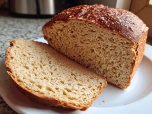 A freshly baked whole wheat bread loaf, sliced open to show the soft, airy crumb texture.