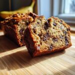 A close-up of sliced chocolate chip banana bread showing moist texture and melted chips.
