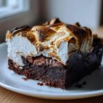 Close-up of a fudgy hot chocolate brownie topped with a thick layer of toasted, golden-brown marshmallow.