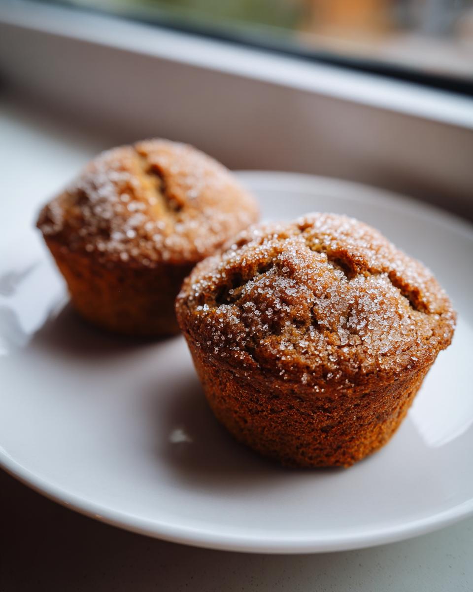 Close-up of two moist mini banana bread loaves topped generously with sparkling coarse sugar.