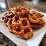 A pile of crunchy, glazed toffee pretzels sprinkled with salt, ready to eat.