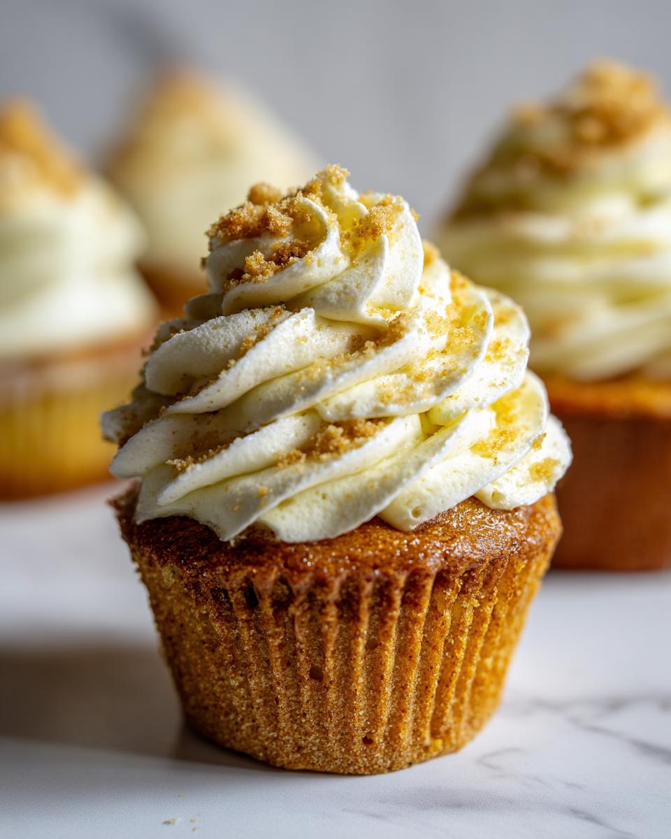A single, perfectly baked banana pudding cupcakes topped with a swirl of creamy frosting and graham cracker crumbs.
