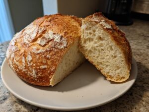 A freshly baked loaf of Italian bread, sliced in half to reveal the airy, open crumb structure.