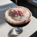A rich peppermint espresso martini topped with thick foam and crushed candy canes.