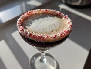 Close-up of a Peppermint Espresso Martini in a coupe glass with a crushed candy cane rim.