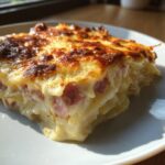 Close-up of a rich, cheesy slice of scalloped potatoes and ham with a perfectly browned top.