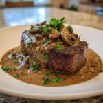 Thick-cut steak smothered in rich, creamy mushroom sauce and topped with sliced mushrooms and parsley.