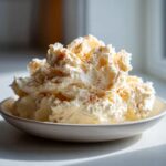 A mound of fluffy, whipped honey butter sprinkled with cinnamon, served in a small bowl.