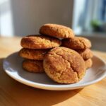 A stack of freshly baked brown butter snickerdoodles coated in cinnamon sugar, resting on a white plate.