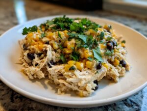 A serving of southwest crockpot chicken and rice topped with melted cheese and fresh cilantro.