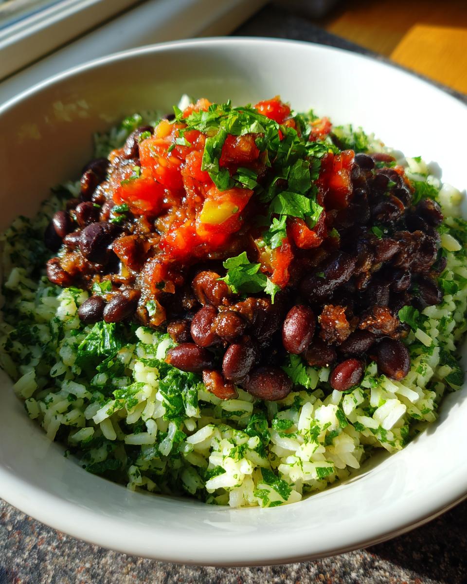 A close-up, sunlit view of a black bean and rice bowl featuring cilantro-lime rice topped with seasoned black beans, salsa, and fresh parsley.